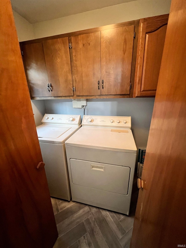 washroom with cabinets, dark parquet floors, and independent washer and dryer