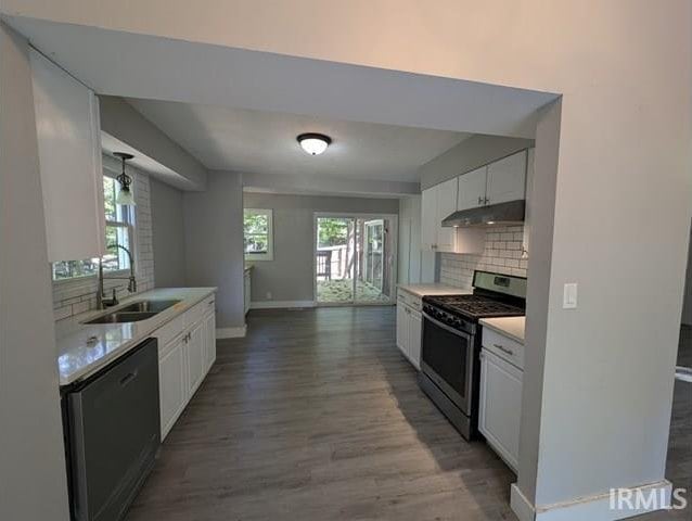 kitchen with black dishwasher, stainless steel range oven, a wealth of natural light, and white cabinetry