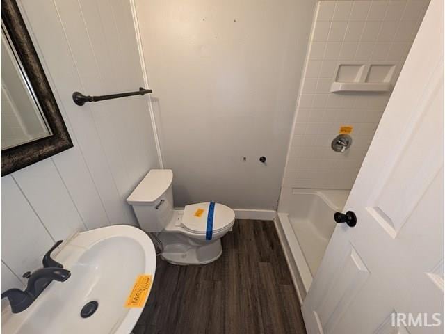 full bathroom featuring a sink, toilet, a shower, wood finished floors, and baseboards