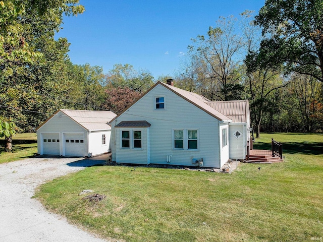 view of front of home featuring an outbuilding, a front lawn, and a garage