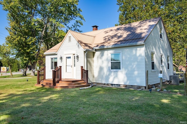 bungalow-style house with a wooden deck, cooling unit, and a front lawn