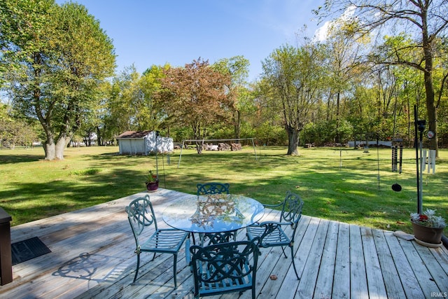 wooden terrace featuring a storage shed and a lawn