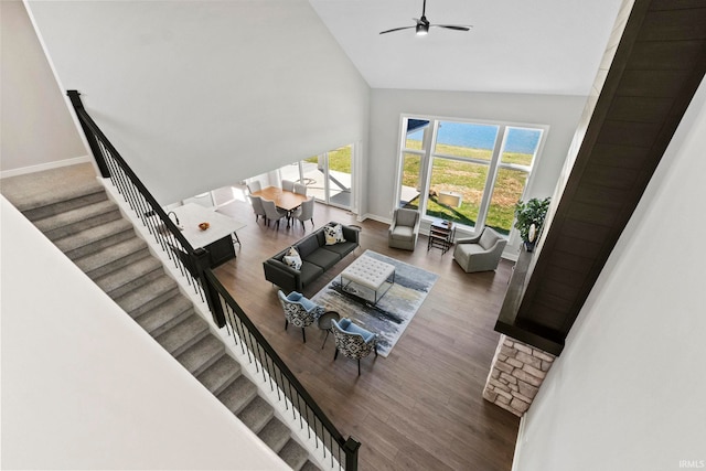 living room with ceiling fan, hardwood / wood-style floors, and high vaulted ceiling