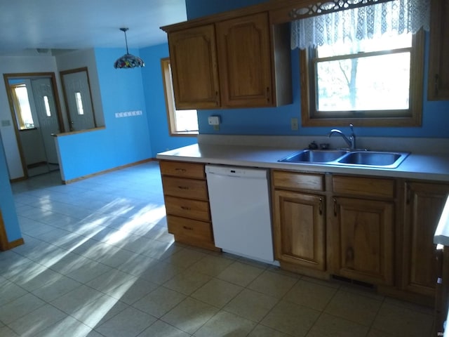 kitchen with dishwasher, light tile patterned flooring, decorative light fixtures, and sink