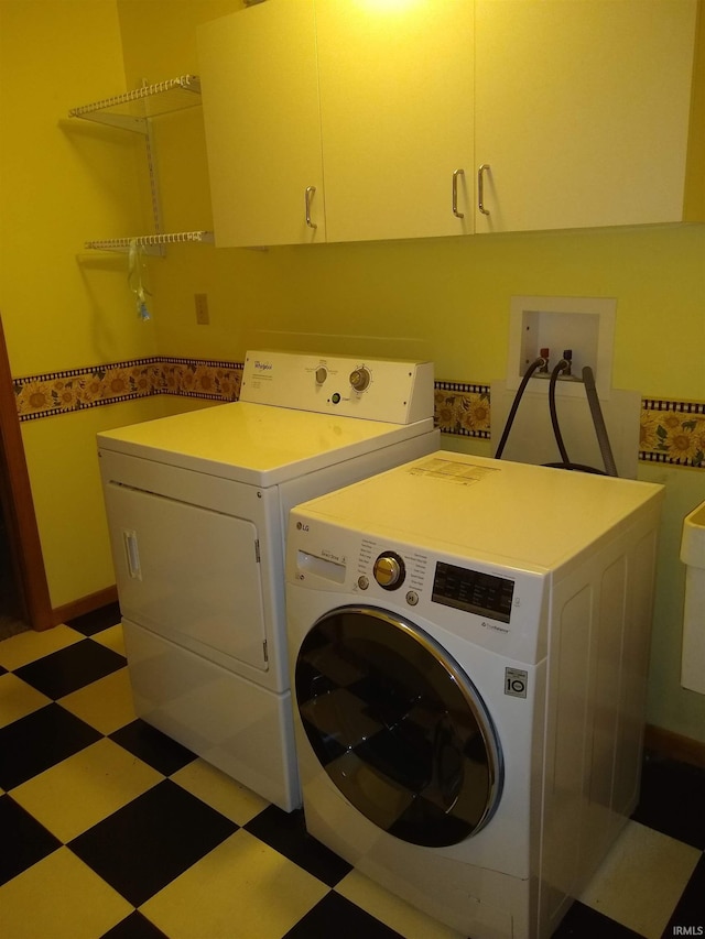 laundry room featuring washer and dryer and cabinets