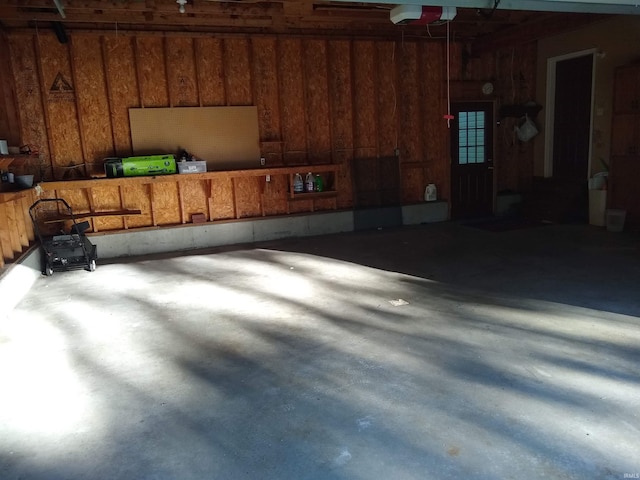 garage featuring a garage door opener and wood walls