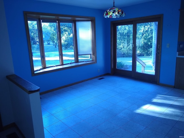 spare room with light tile patterned flooring and plenty of natural light