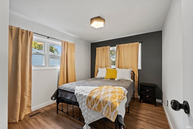 bedroom with hardwood / wood-style floors and multiple windows