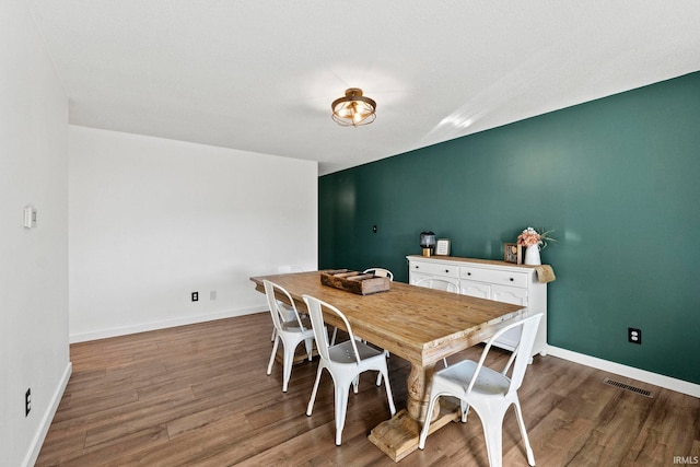 dining space with wood-type flooring