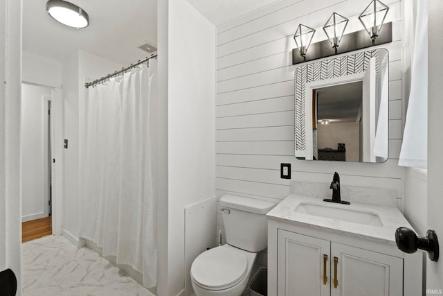 bathroom with vanity, wooden walls, toilet, and curtained shower