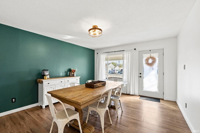 dining area with a textured ceiling and hardwood / wood-style floors