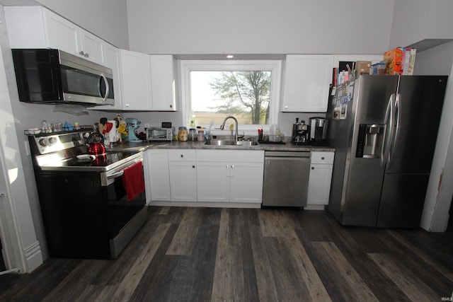 kitchen with appliances with stainless steel finishes, dark wood-type flooring, sink, and white cabinetry