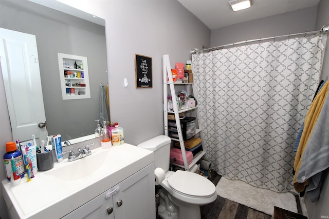 bathroom with walk in shower, vanity, hardwood / wood-style floors, and toilet