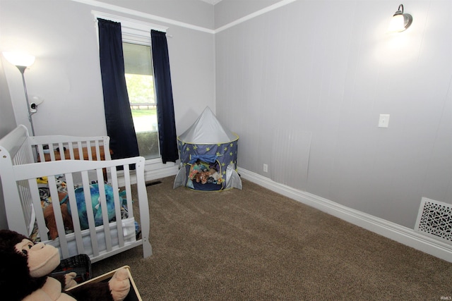 carpeted bedroom featuring a nursery area