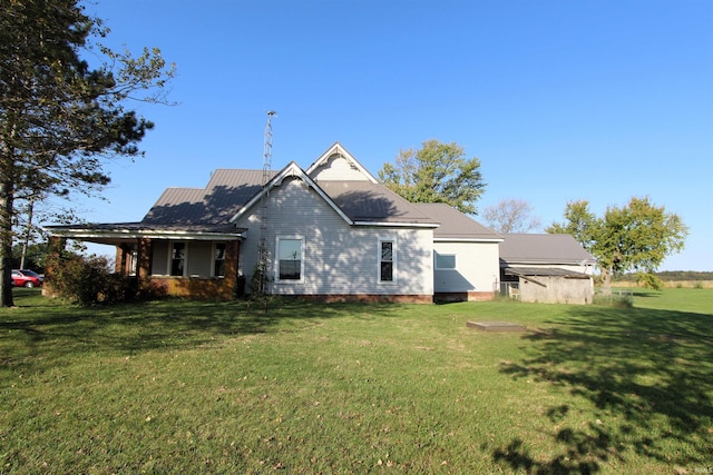 rear view of property featuring a lawn