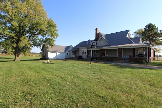 rear view of house featuring a garage, a porch, and a lawn