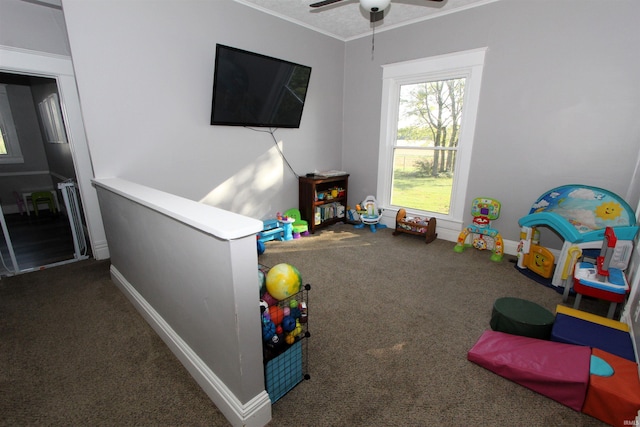 recreation room featuring dark carpet and ceiling fan