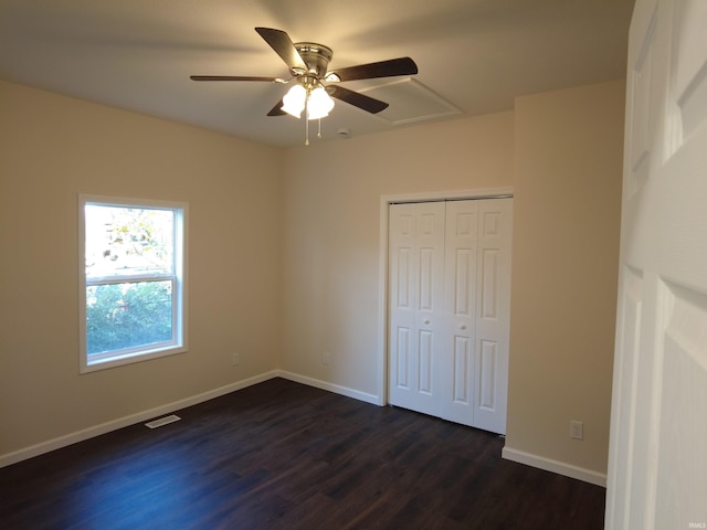 unfurnished bedroom featuring ceiling fan, a closet, and dark wood-type flooring