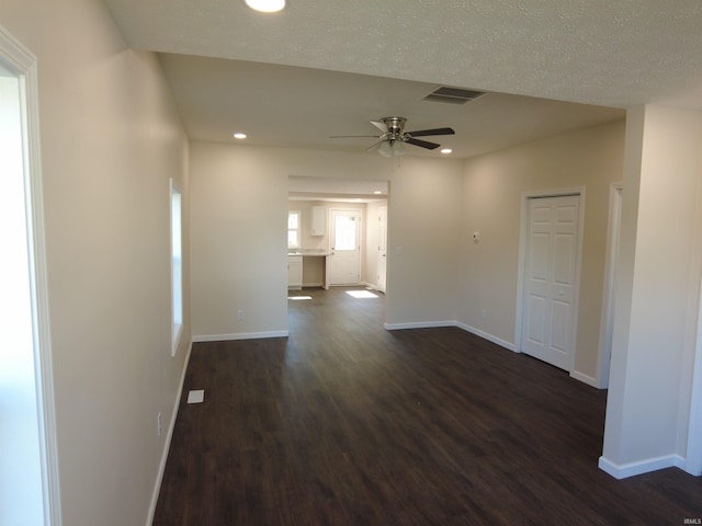 interior space with ceiling fan, a textured ceiling, and dark hardwood / wood-style floors