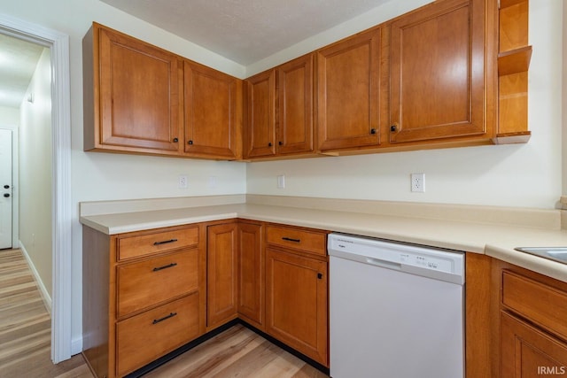 kitchen with dishwasher, light hardwood / wood-style floors, and a textured ceiling