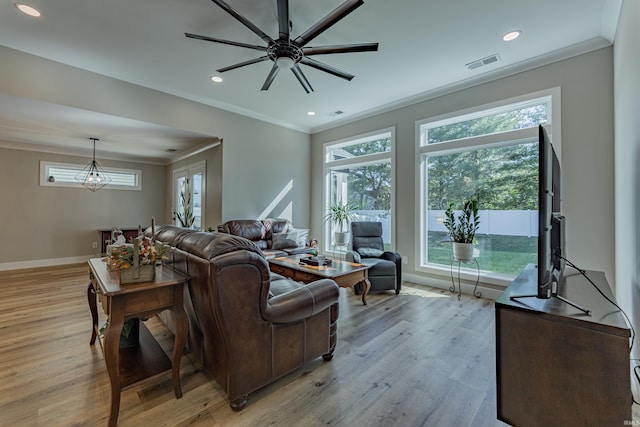 living room with crown molding, ceiling fan with notable chandelier, and light hardwood / wood-style floors