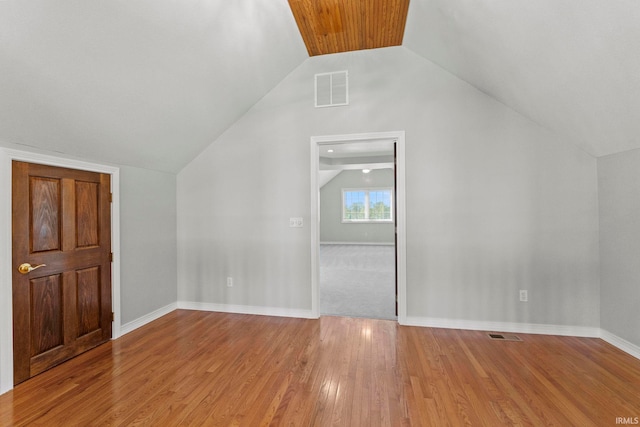 bonus room with light wood-type flooring and vaulted ceiling