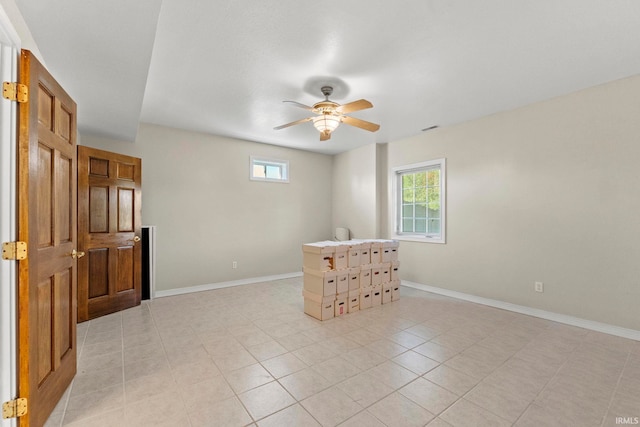 tiled empty room with a wealth of natural light and ceiling fan