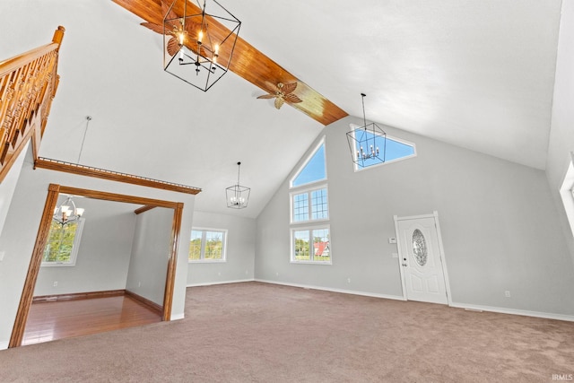 unfurnished living room with high vaulted ceiling and carpet