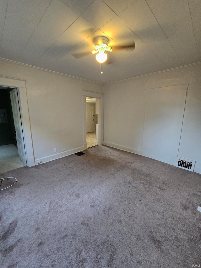 unfurnished room with crown molding, ceiling fan, and carpet floors