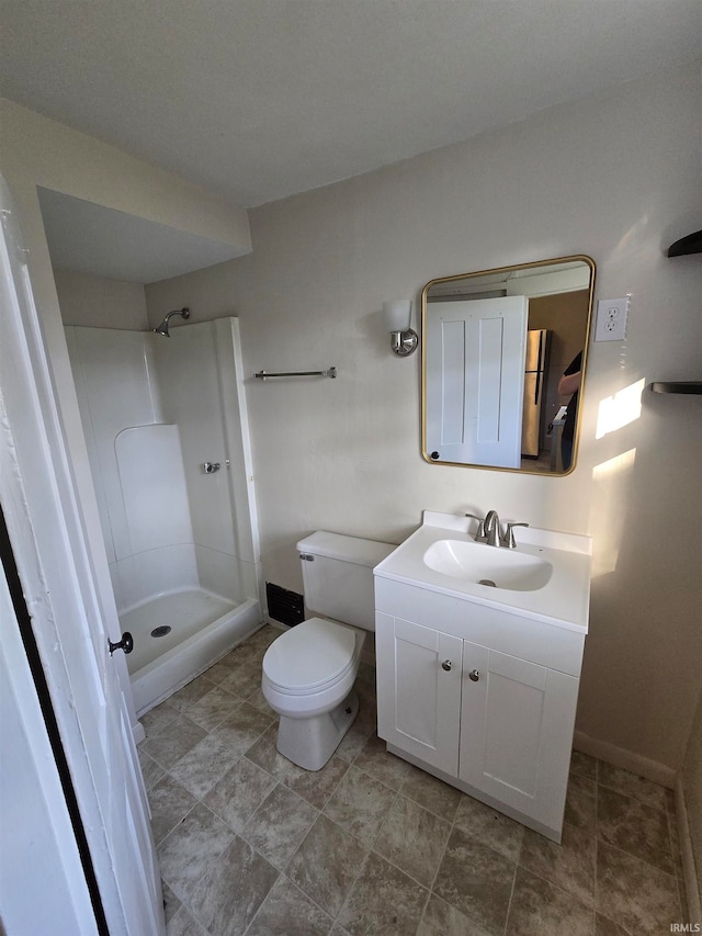 bathroom featuring walk in shower, vanity, and toilet