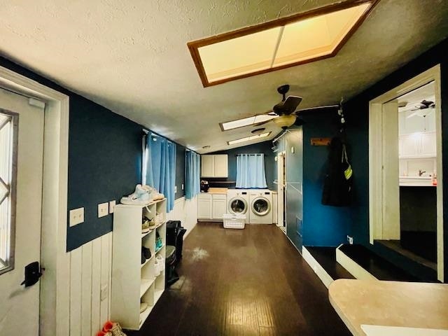 interior space featuring ceiling fan, washer and clothes dryer, dark hardwood / wood-style flooring, cabinets, and a textured ceiling