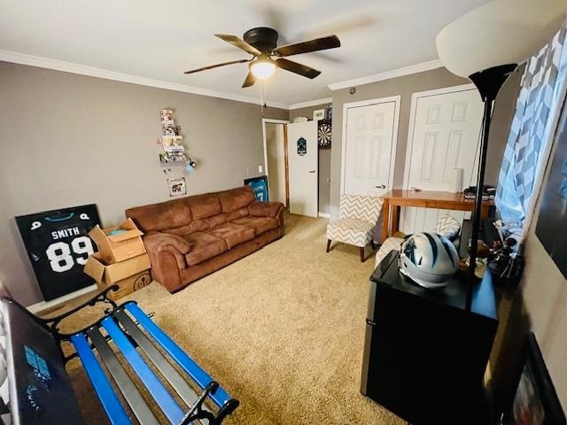 carpeted living room featuring ornamental molding and ceiling fan