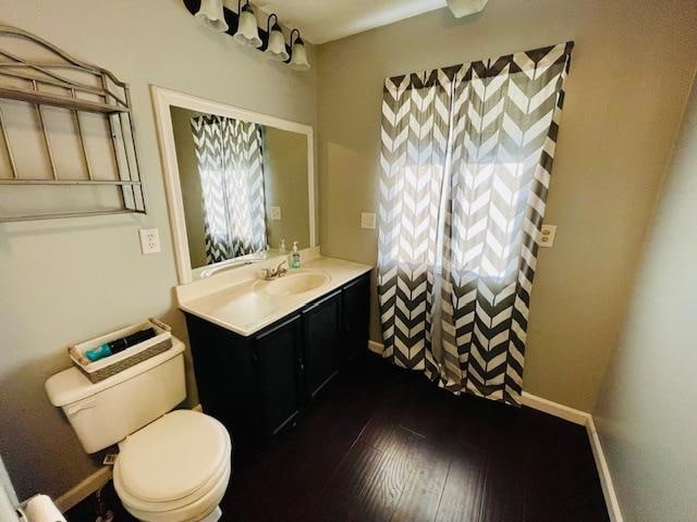 bathroom featuring vanity, toilet, and hardwood / wood-style flooring