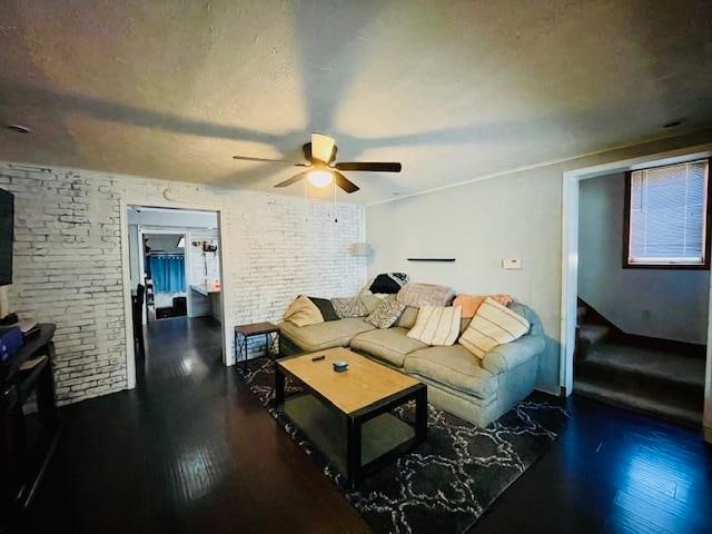 living room featuring ceiling fan and dark hardwood / wood-style floors