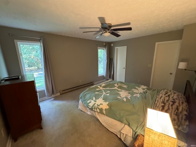 carpeted bedroom featuring a baseboard heating unit, a textured ceiling, and ceiling fan