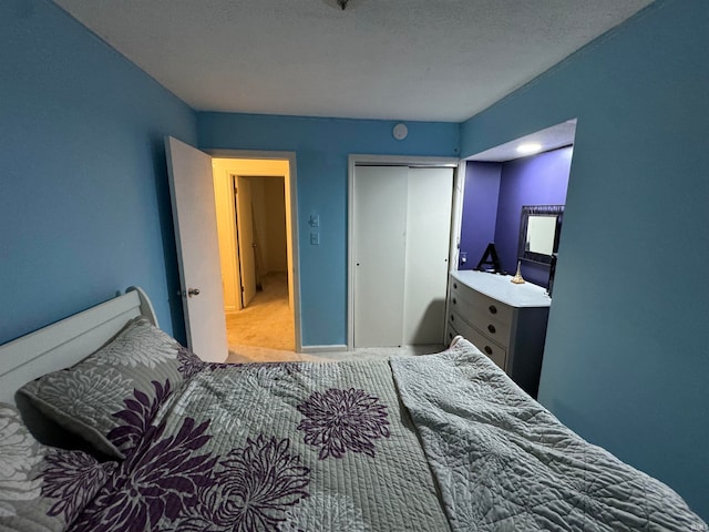 carpeted bedroom featuring a closet and a textured ceiling