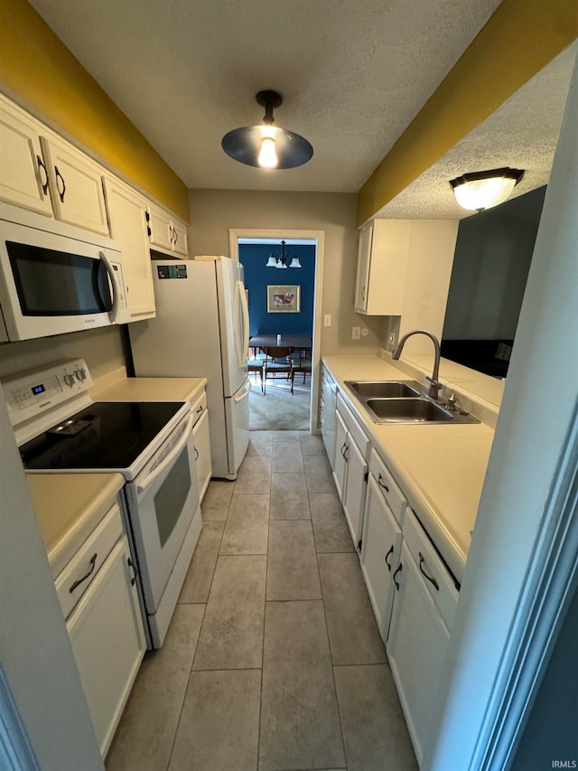 kitchen featuring sink, light tile patterned floors, white cabinetry, a textured ceiling, and white appliances