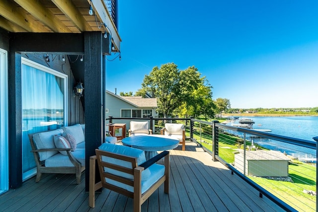 wooden terrace with an outdoor hangout area and a water view