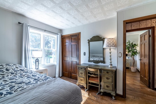 bedroom with dark hardwood / wood-style floors and wooden walls