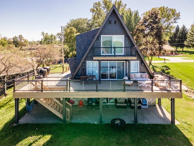 back of property with outdoor lounge area, a yard, and a wooden deck