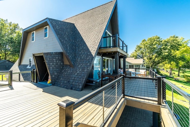 back of house with a deck and a balcony