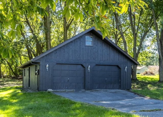 garage featuring wood walls and a yard