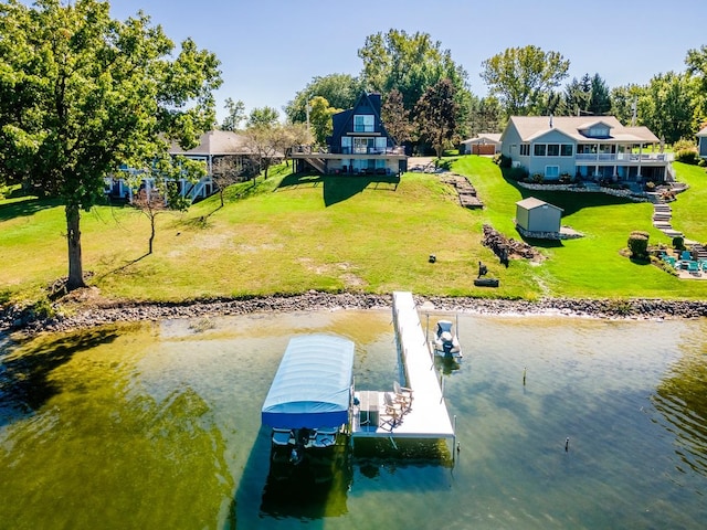 view of dock with a water view and a lawn