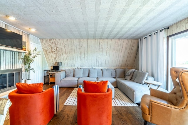 living room with lofted ceiling, dark hardwood / wood-style floors, and wooden walls