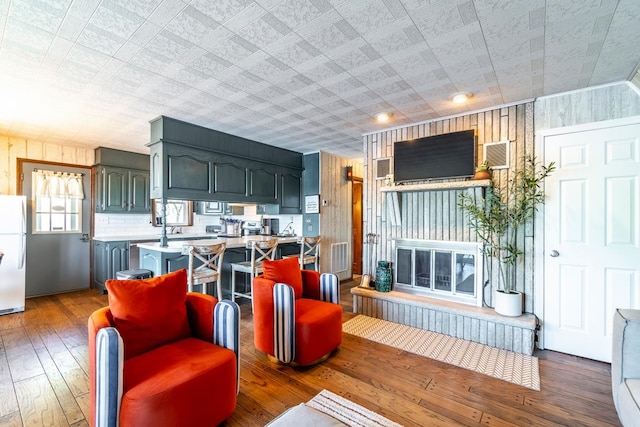 living room featuring wooden walls and hardwood / wood-style floors