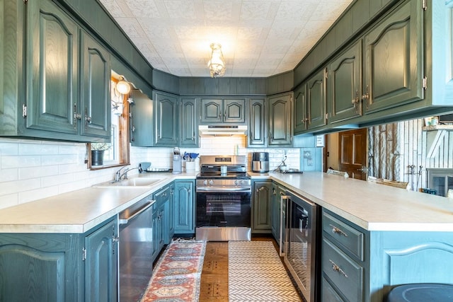 kitchen with tasteful backsplash, wine cooler, sink, kitchen peninsula, and appliances with stainless steel finishes