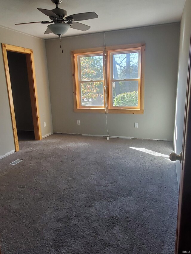 carpeted empty room featuring ceiling fan