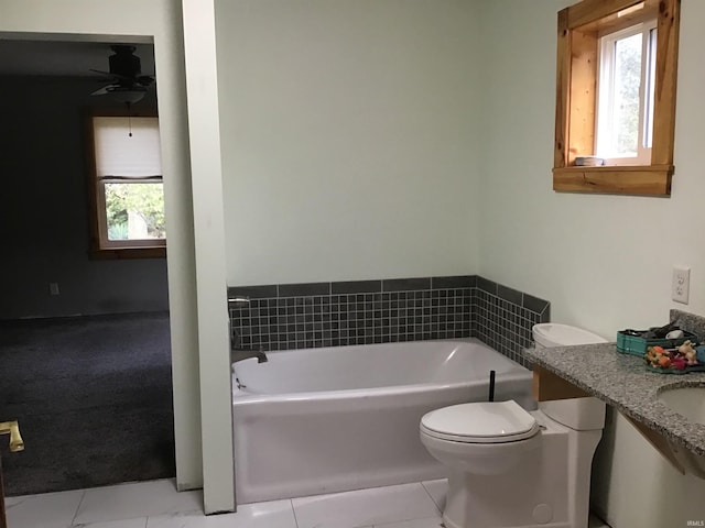 bathroom featuring ceiling fan, vanity, tile patterned flooring, a bathtub, and toilet