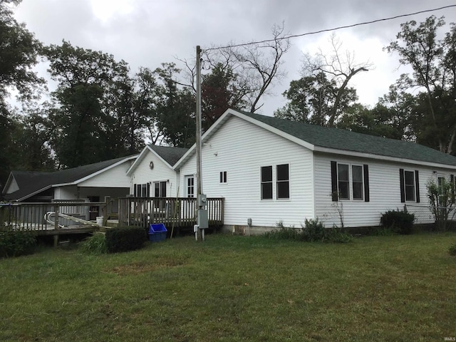 back of property featuring a yard and a wooden deck