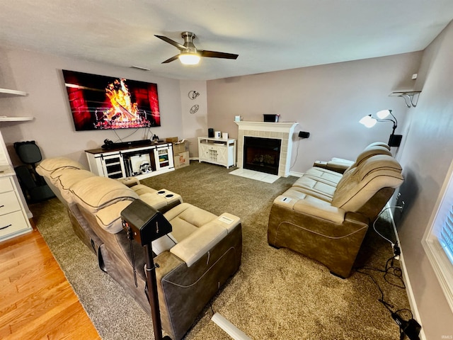 living room with ceiling fan, light hardwood / wood-style floors, and a fireplace